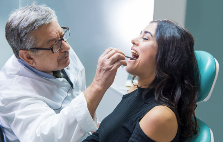 A dentist conducting and oral cancer screening.