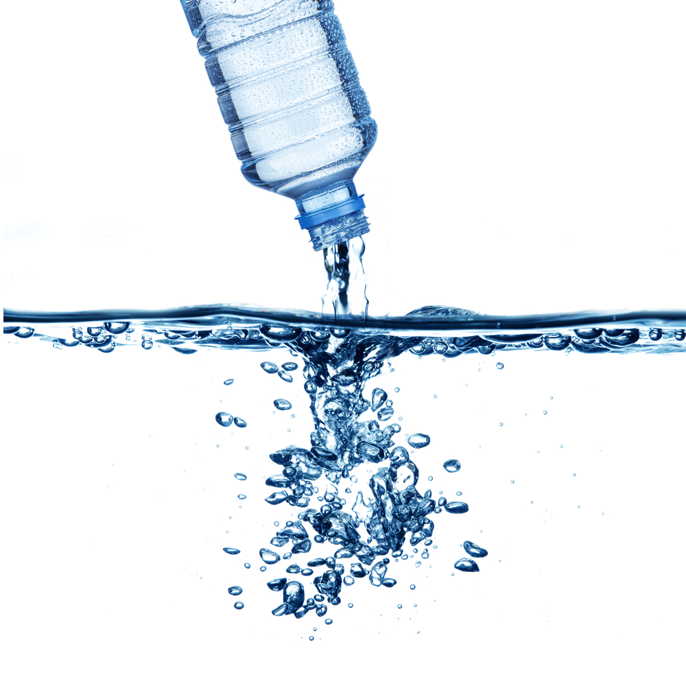 Bottle of water being poured into water, shows bubbles underwater