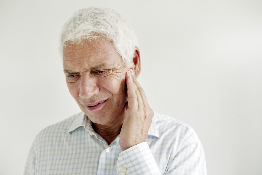 Man holding jaw in pain