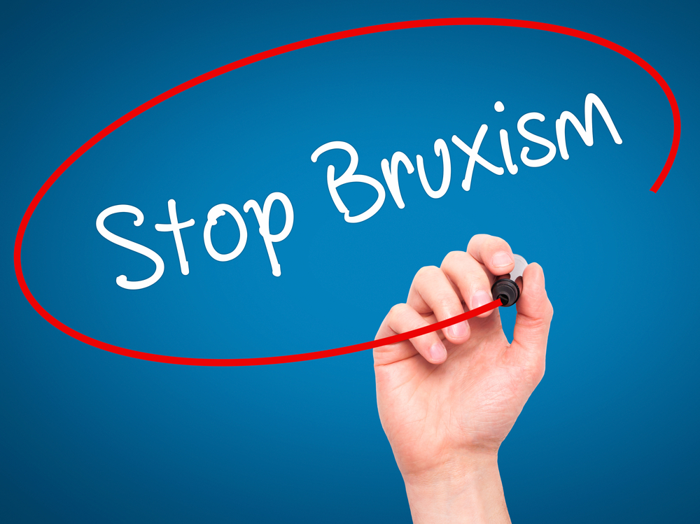 Person circling the word "Stop Bruxism" with red marker on blue background