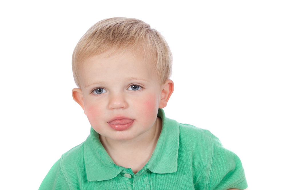 Little toddler boy with tongue between lips