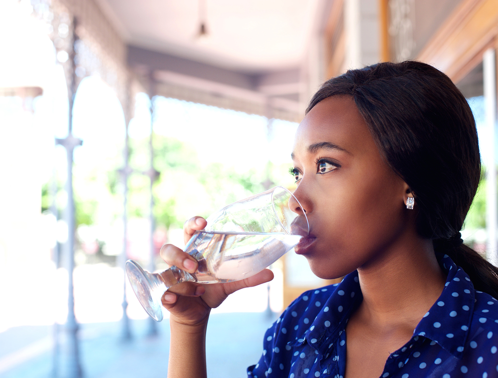 Woman drinking a glass of water on a beautiful sunny day