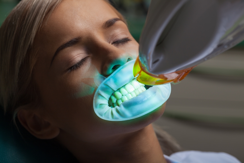 Woman patient receiving Zoom laser teeth whitening treatment
