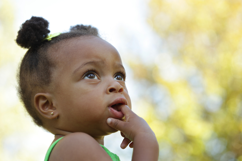 Little toddler girl with finger in her mouth