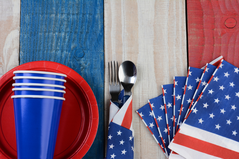 Patriotic plates cups napkins on red white and blue picnic table for 4th of July