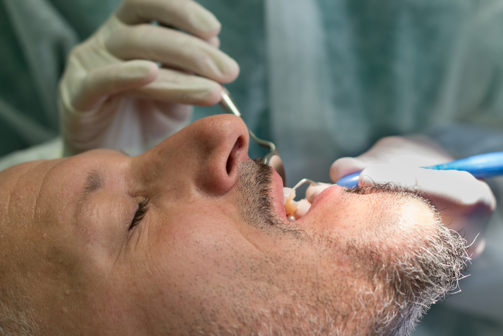 Male patient being examined by dentist