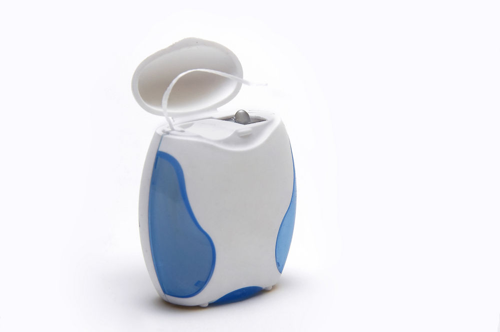 Dental floss in blue and white container