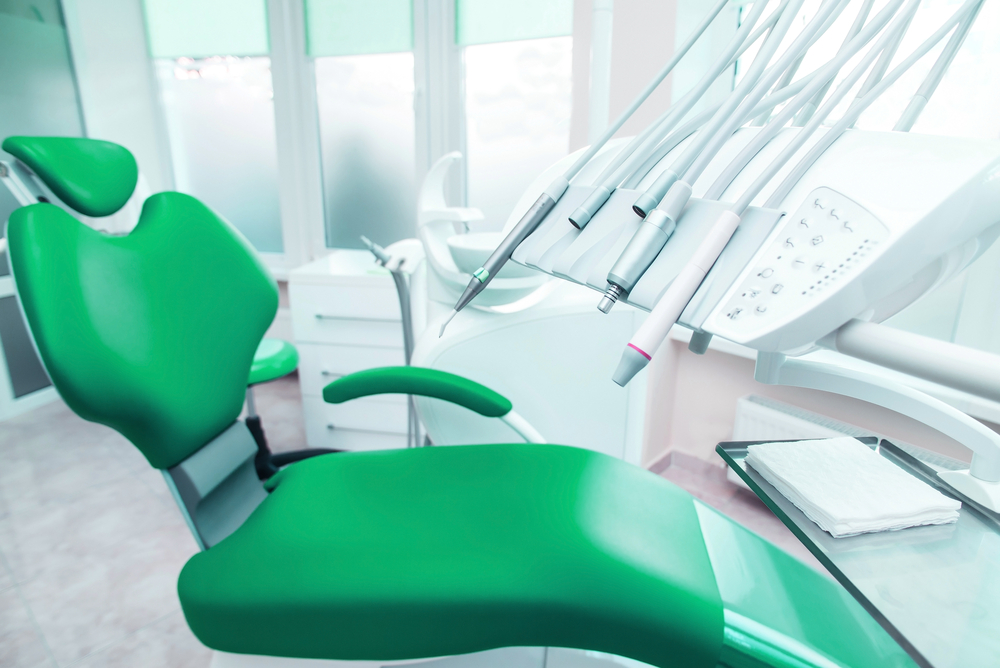 Green dental examination chair with dental tools