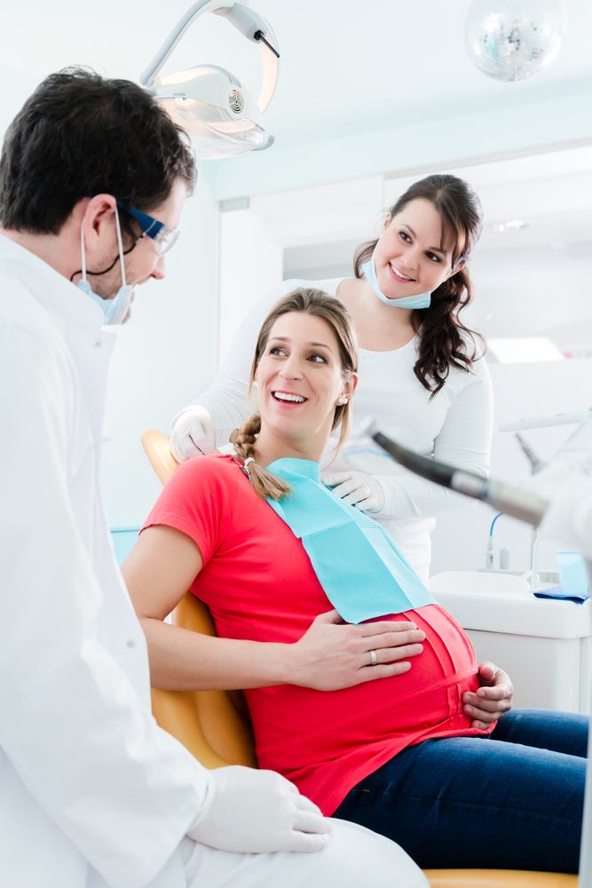 pregnant woman with 2 dentists, all smiling