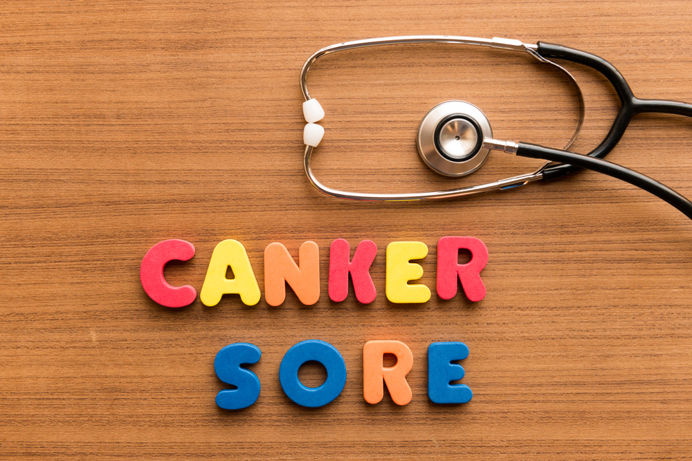 canker sore colorful word on the wooden background with stethoscopeq