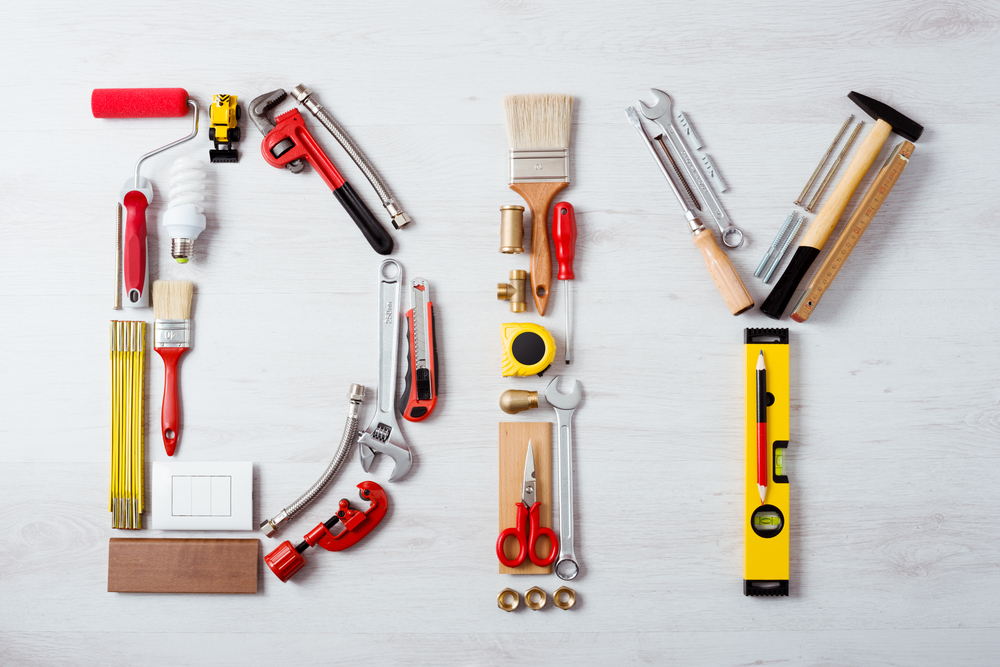 DIY word composed of work and construction tools on a wooden surface top view, hobby and craft concept