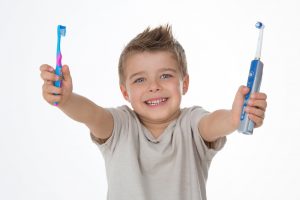 joyful kid raises his toothbrushes