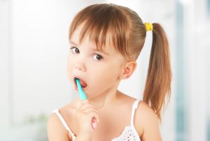 kid's dental hygiene. happy little girl brushing her teeth