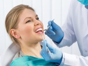 Pulp disease treatment. Root canal therapy. Young woman in dentist office curing painful tooth.