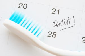 Dentist appointment date on calendar with toothbrush.
