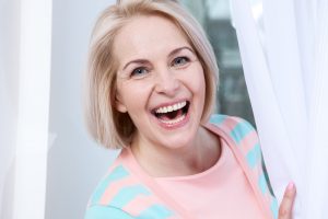 woman with 2 front teeth smiling