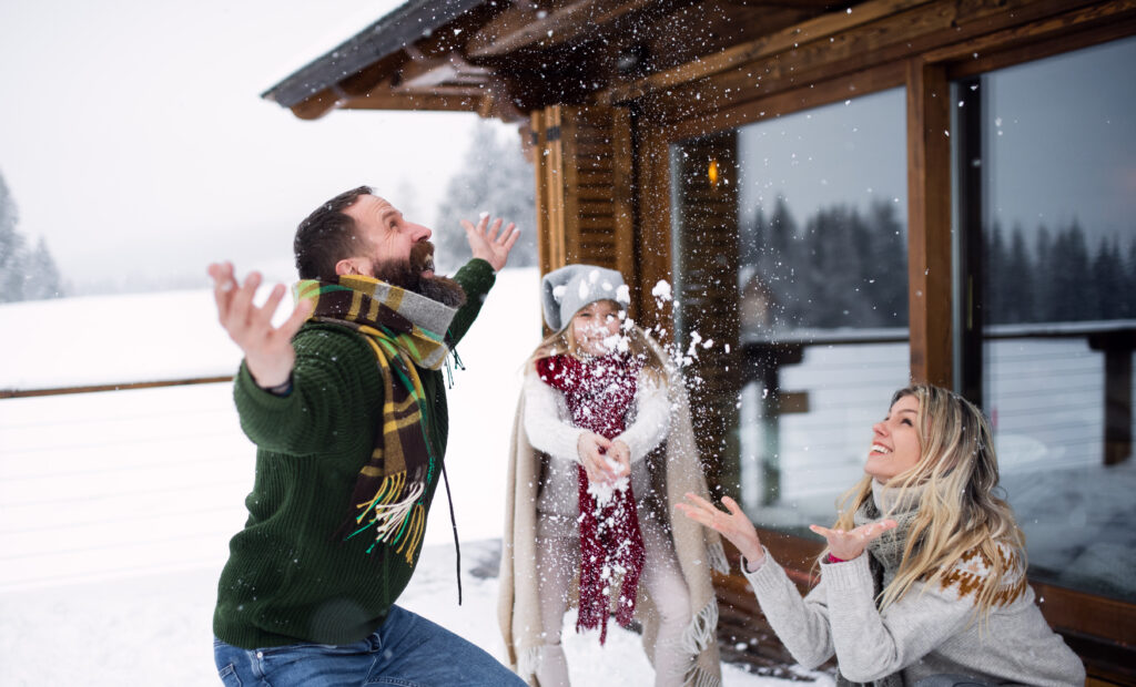 family playing the snow during the holidays