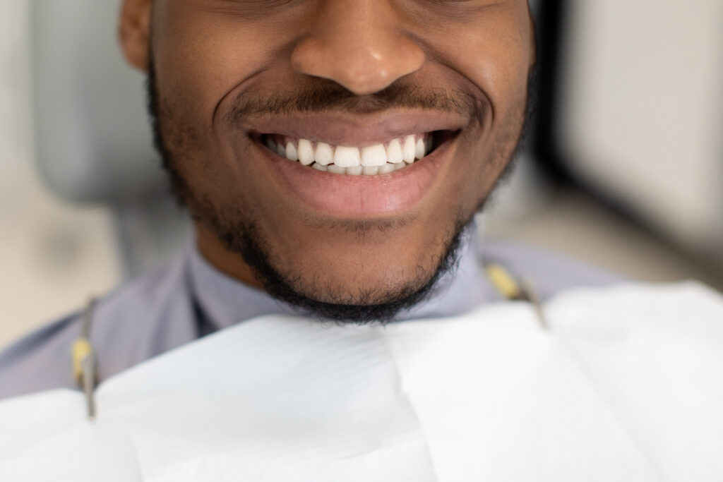 man smiling with healthy gums and teeth after dental prodecure
