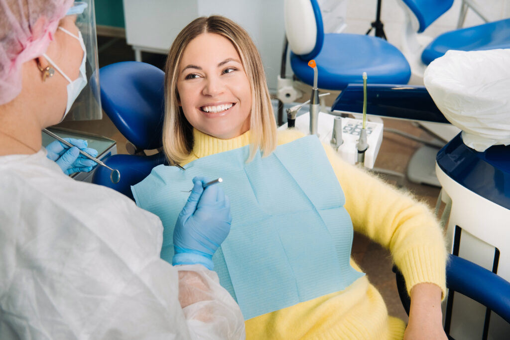 woman sitting in dental chair smiling at her orthodontist