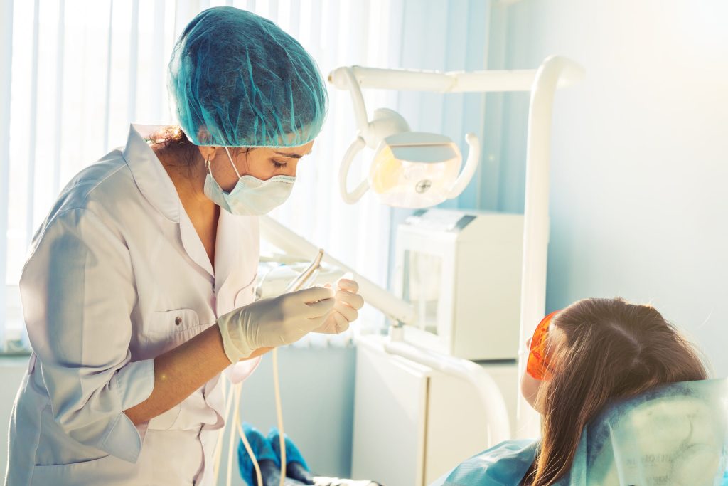 a young female dentist working on a patient