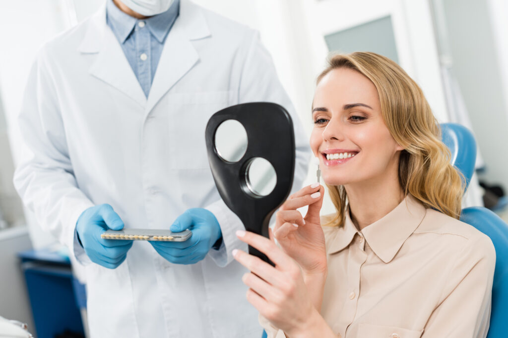woman choosing tooth implant looking in mirror