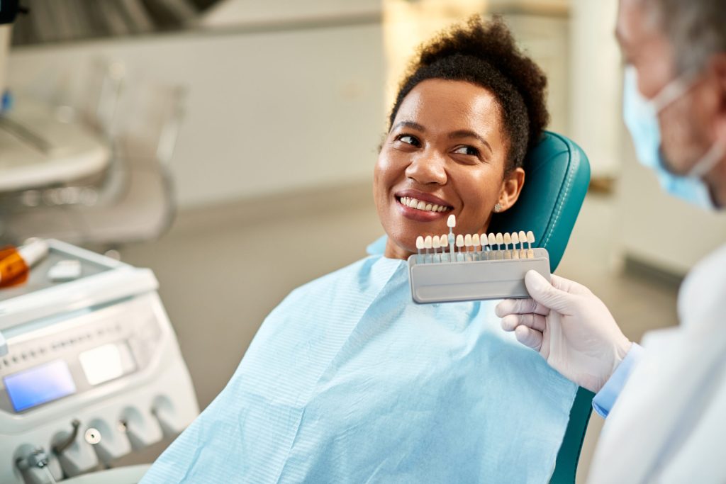 woman choosing a shade for her veneers at the dentist