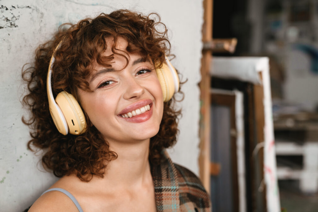 smiling you woman in headphones enjoying her LANAP results