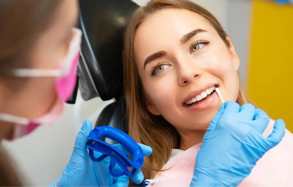 a woman having her teeth cleaned by a dentist