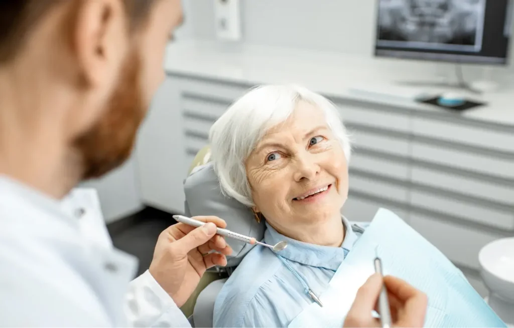 elderly woman speaking with a dentist