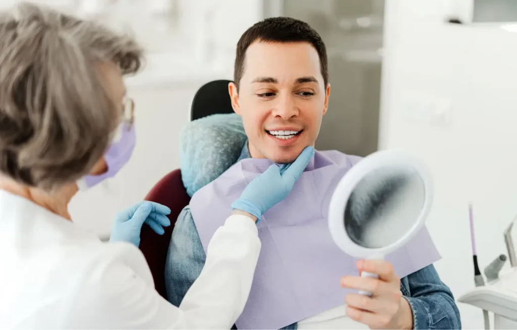 a dental patient inspecting his veneers