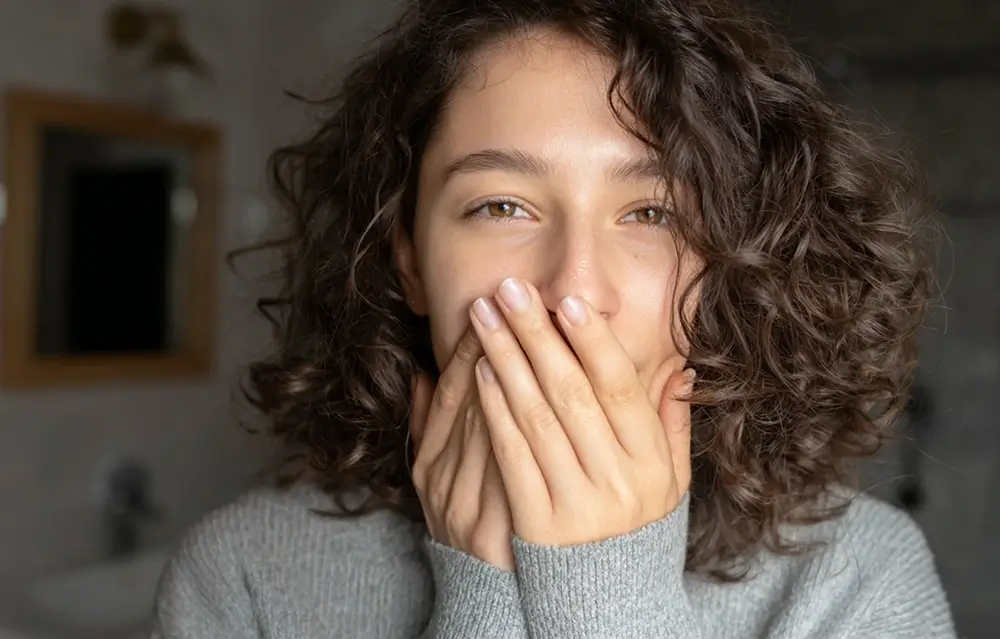 a woman holding her mouth in pain