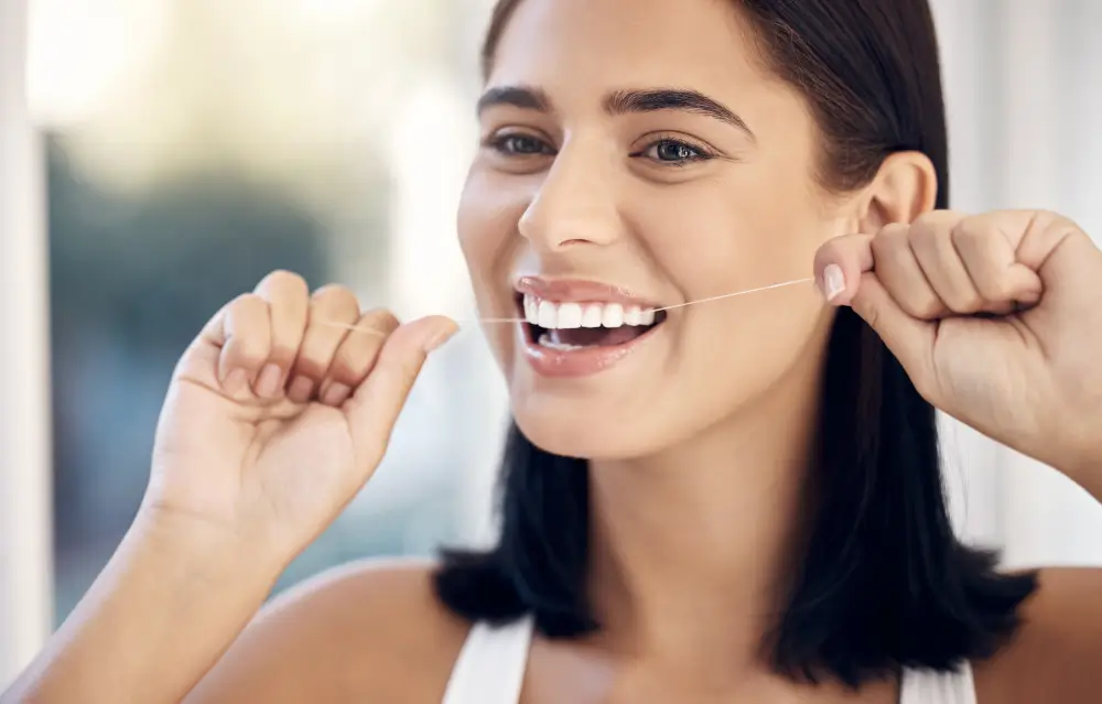 A woman flossing her teeth